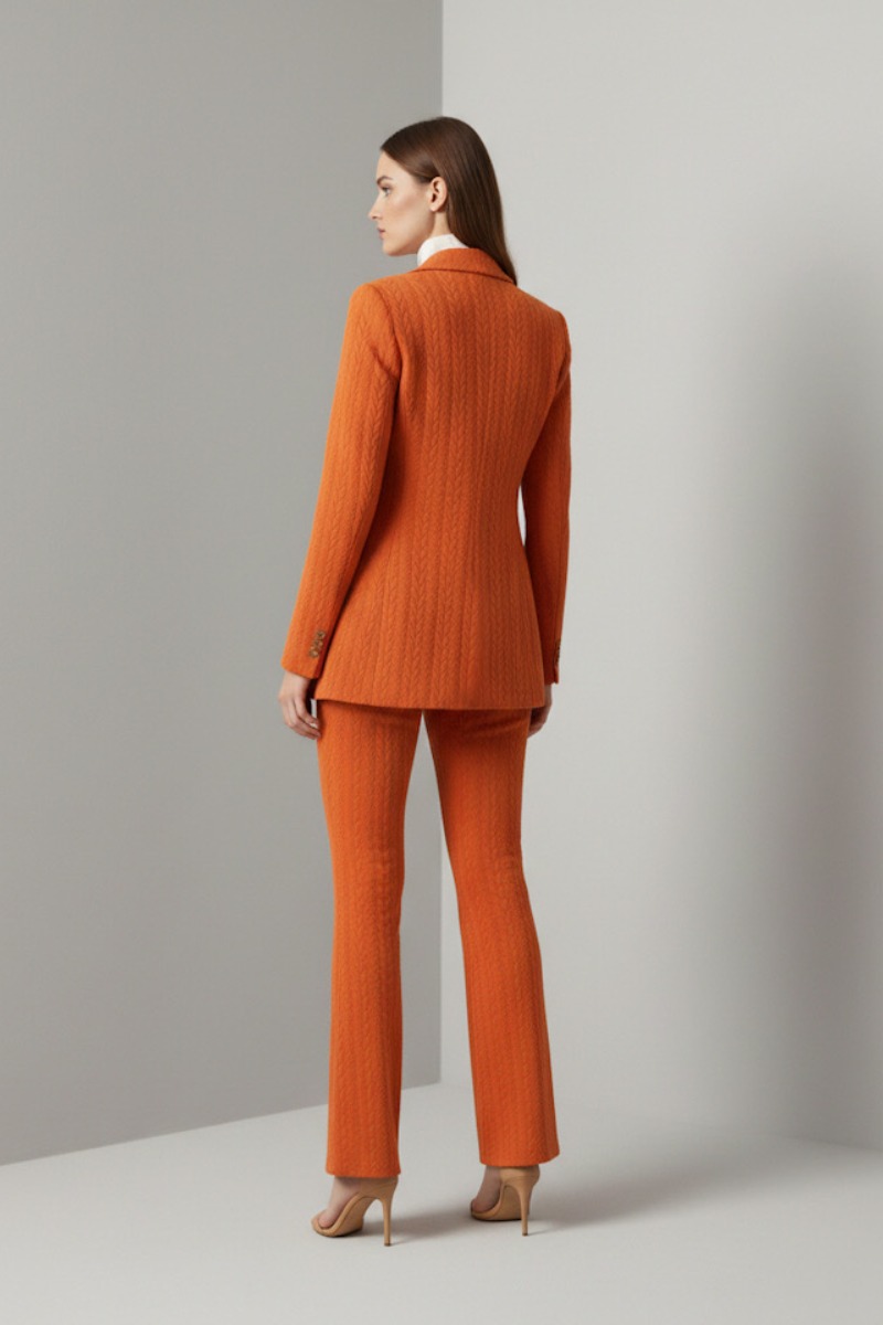 Garnitur damski pomarańczowy – widok z tyłu, taliowana marynarka i szerokie spodnie dzwony